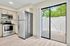 Chic modern kitchen with stainless steel appliances and bright sliding glass door leading to a private patio.