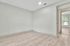 Spacious room with elegant wood-style flooring and a sunlit window view, perfect for creating a cozy living space.