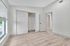 Bright bedroom with elegant wood flooring, large window for natural light, and spacious closet.