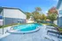 Inviting outdoor pool area with comfortable lounge chairs and shaded picnic tables, perfect for relaxation.