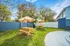 Charming outdoor garden with wooden picnic tables and umbrellas, surrounded by lush greenery, perfect for relaxation and gatherings.