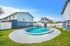 Inviting apartment complex with a pristine pool surrounded by sun loungers, perfect for relaxation in a lush outdoor setting.