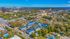 Vibrant aerial view of a lively neighborhood featuring colorful buildings, lush greenery, and a thrilling amusement park nearby.