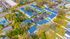 Vibrant aerial view of a charming apartment complex featuring blue-roofed buildings, ample parking, and a refreshing central pool, nestled in a serene neighborhood.