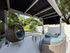 Charming and cozy outdoor patio with stylish wicker seating, elegant canopy, and lush green garden view.