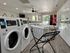 Modern laundry room featuring sleek Speed Queen commercial washers and a stylish laundry cart, offering a bright and efficient space for effortless clothes care.