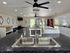 Modern laundry room with sleek countertop, stainless steel sink, ample washers and dryers, and stylish ceiling fan.