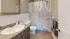 Elegant bathroom featuring a sleek countertop, modern fixtures, and a stylish geometric shower curtain.