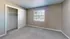Bright and cozy bedroom with plush carpeting and large window, featuring a spacious closet with sliding doors.