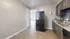 Charming kitchen with modern dark wood cabinets, granite countertops, and sleek appliances, leading to a bright and airy living space.