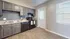 Modern kitchen with elegant gray cabinetry, sleek black appliances, and ample natural light.
