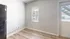 Bright kitchen corner featuring sleek hardwood floors, modern refrigerator, and ample natural light through a window and glass door.