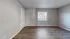 Bright and inviting room with large window and stylish wood flooring, perfect blank canvas for customization.