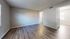 Spacious and well-lit room with elegant hardwood floors and fresh white walls, ideal for versatile living space.