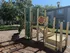 Inviting playground with a slide and climbing structure surrounded by lush greenery, perfect for family fun in a tranquil apartment community.