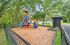 Inviting playground area with colorful slides and climbing structures in a serene, fenced park setting.