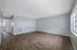 Bright and inviting living area with elegant wooden flooring and large window, perfect for a cozy home atmosphere.