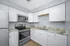 Modern kitchen with sleek stainless steel appliances, elegant granite countertops, and stylish white cabinetry.