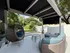 Charming patio with modern wicker furniture, featuring a cozy hanging chair and stylish seating, surrounded by lush greenery and shaded by an elegant canopy.