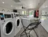 Modern laundry room featuring state-of-the-art washing machines and a stylish laundry cart, ideal for convenient and efficient living.