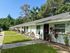 Charming row of single-story homes with lush greenery and modern landscaping in a serene neighborhood setting.