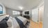 Inviting bedroom with a plush bed, sleek modern furniture, and a large window for natural light.