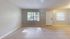 Bright and spacious living area with tiled flooring and large windows, perfect for modern living.