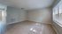 Bright, open living space with large windows and neutral tile flooring, perfect for customization and natural light enjoyment.