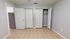 Bright bedroom with sleek tiled flooring, ample closet space featuring dual doors, and freshly painted walls.