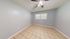 Bright, spacious room with modern ceiling fan and elegant tiled flooring, perfect for a cozy living space or home office.