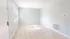 Bright and inviting room with large window, neutral tile flooring, and ample natural light.