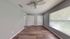 Bright and airy bedroom with modern gray walls, elegant wooden flooring, and ample closet space, enhanced by a large sunlit window.