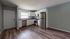 Modern kitchen with sleek stainless steel appliances, elegant white cabinetry, and warm wood flooring, offering an inviting and functional cooking space.