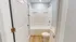 Bright and modern bathroom featuring a sleek bathtub, elegant white fixtures, and stylish wooden flooring.