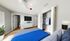 Bright and modern bedroom featuring a cozy bed with blue bedding, sleek white furniture, and ample closet space.