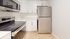 Chic modern kitchen with sleek stainless steel appliances, white cabinetry, and ceramic tile flooring.