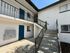 Inviting apartment entrance with modern design, featuring a vibrant blue door, accessible stairway, and stylish railings.