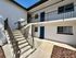 Inviting apartment exterior with a modern staircase leading to blue doors, emphasizing bright and welcoming entryways.
