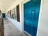 Inviting apartment entrance with a vibrant blue door and charming windows, offering warmth and style.