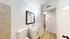 Bright, modern bathroom with elegant fixtures and a spacious layout, featuring a sleek countertop and warm lighting.