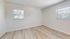 Bright and airy room with sleek hardwood floors and dual windows offering natural light.