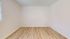 Bright and inviting empty room with elegant wood flooring and pristine white walls, perfect for personalized design.