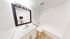 Bright and modern bathroom featuring a sleek vanity, spacious mirror, and pristine white bathtub.
