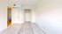 Bright and airy bedroom with light wood flooring, crisp white walls, and ample closet space, offering a fresh canvas for personalized decor.