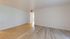 Bright apartment room featuring a mix of elegant tiles and sleek wood flooring with ample natural light.