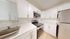Modern kitchen with sleek white cabinetry, stainless steel appliances, and spacious countertops, offering a bright and inviting cooking space.