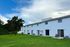 Beautiful townhouse row with vibrant green lawn and serene sky backdrop, ideal for modern suburban living.