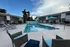 Inviting apartment outdoor area with a sparkling pool, comfortable lounge chairs, and vibrant blue umbrella, perfect for relaxing.