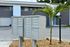 Charming apartment complex with modern mailbox system set amidst lush landscaping and sleek architectural design.