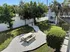 Charming backyard with a picnic table, lush greenery, and a modern BBQ grill, perfect for outdoor relaxation.